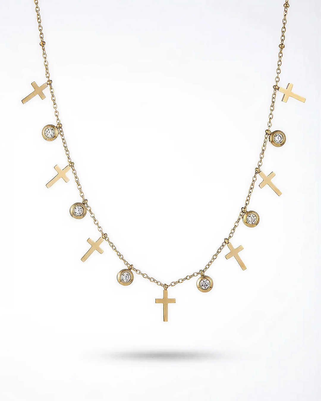 Gold necklace with crosses and small diamonds on a white background