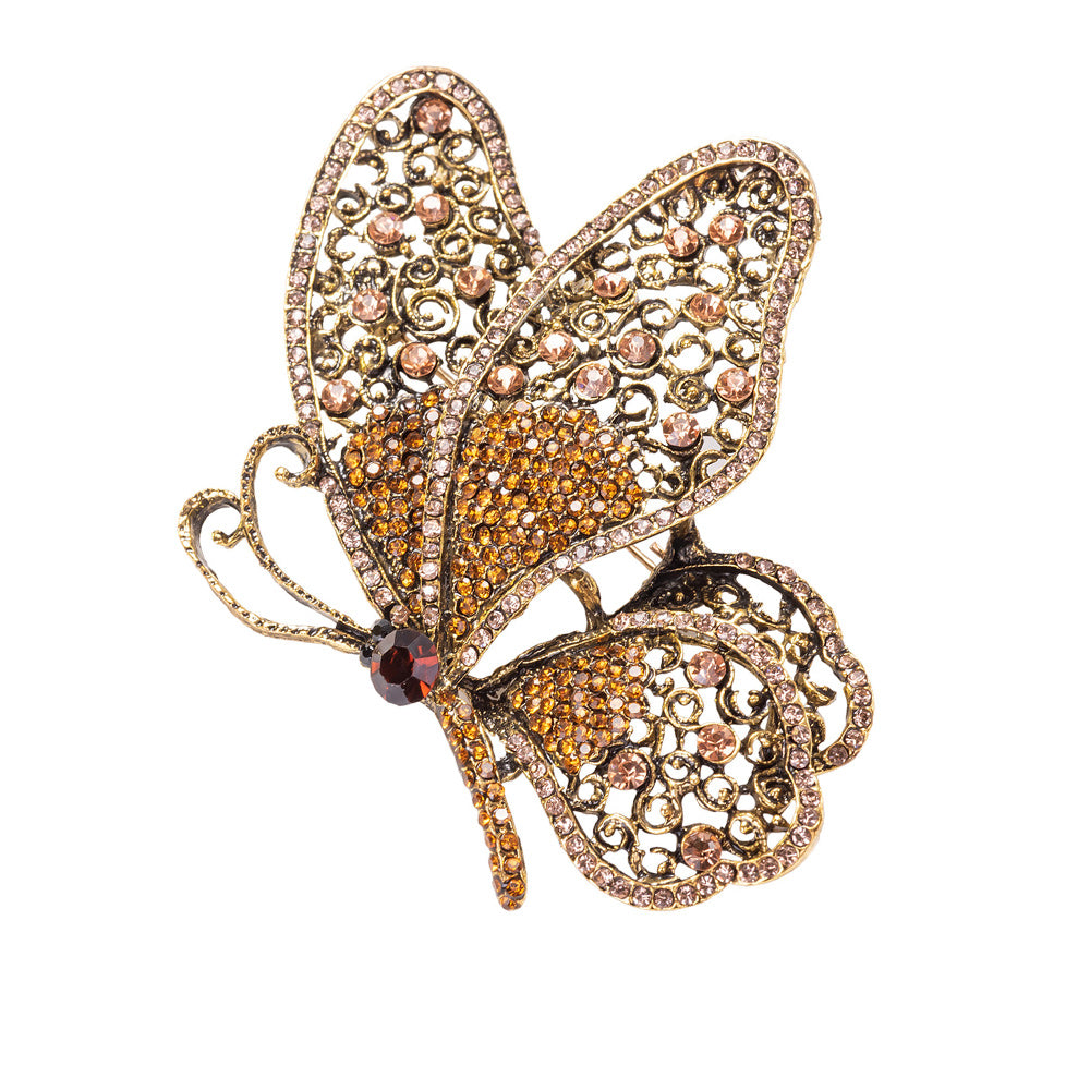 Butterfly-shaped jewelry piece with intricate design and gemstones on a white background