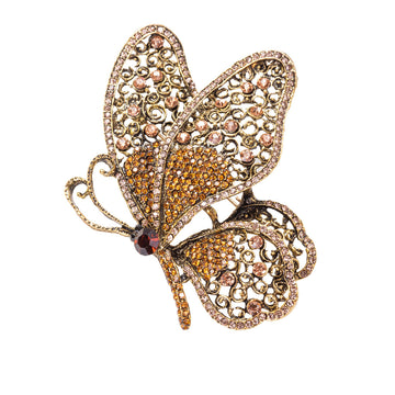 Butterfly-shaped jewelry piece with intricate design and gemstones on a white background