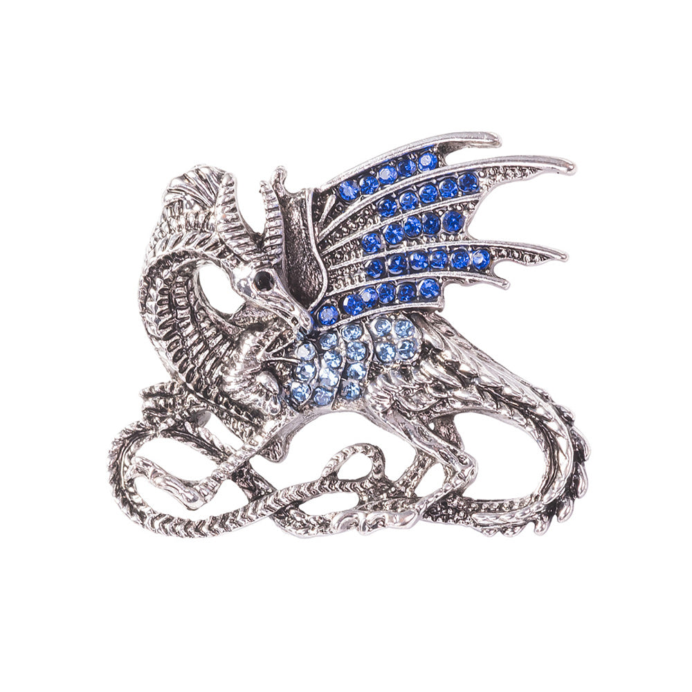 A silver-toned dragon brooch embellished with blue rhinestones on its wings and body, shown on a plain white background.