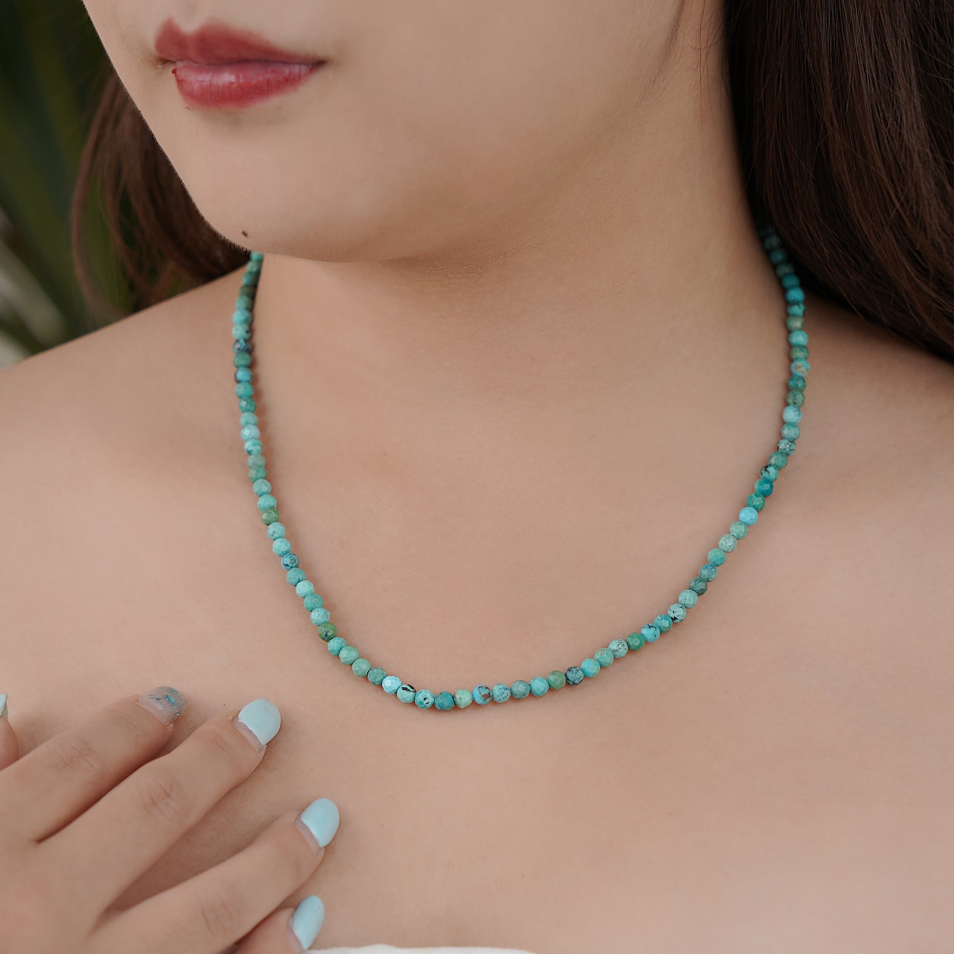 Turquoise beaded necklace worn by a person