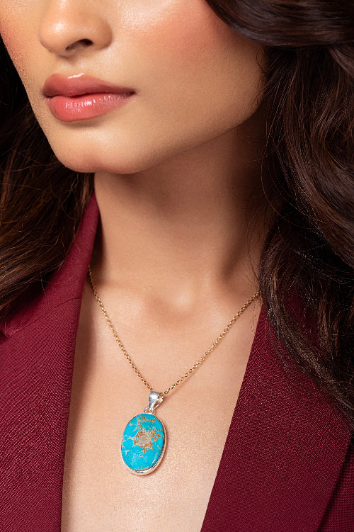 Close-up of a woman wearing a turquoise pendant necklace.
