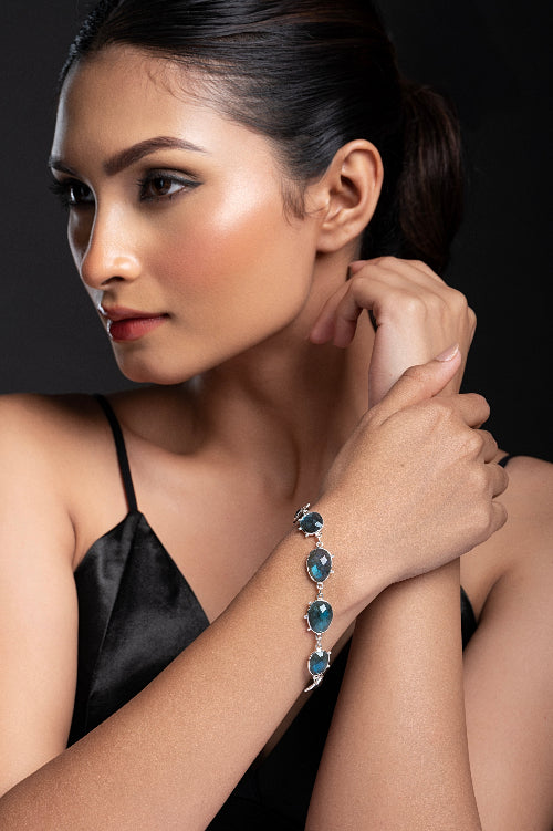 Woman wearing a bracelet with Labradorite gemstones against a dark background