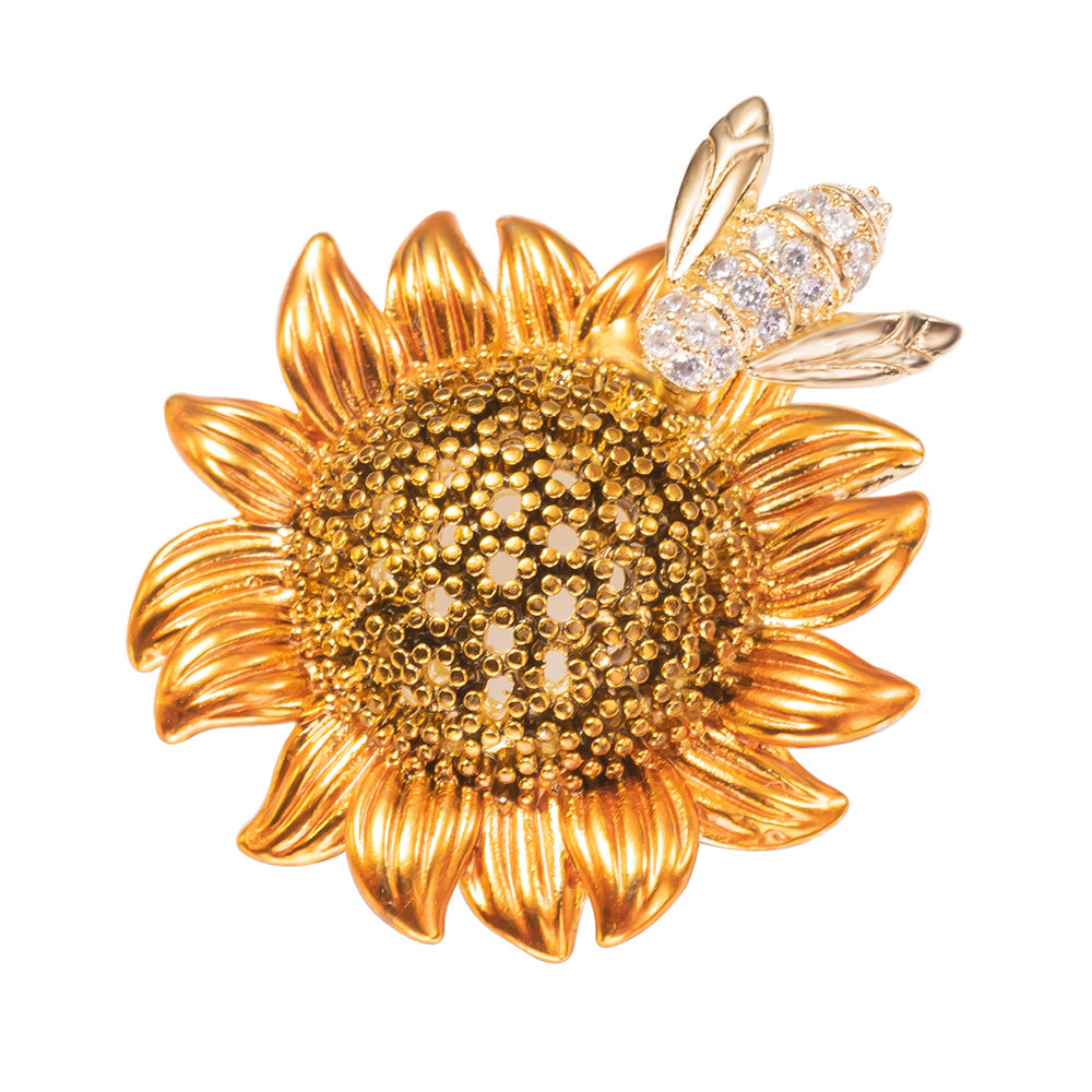 A brooch pin featuring a sunflower with a bee on top, made with cubic zirconia.