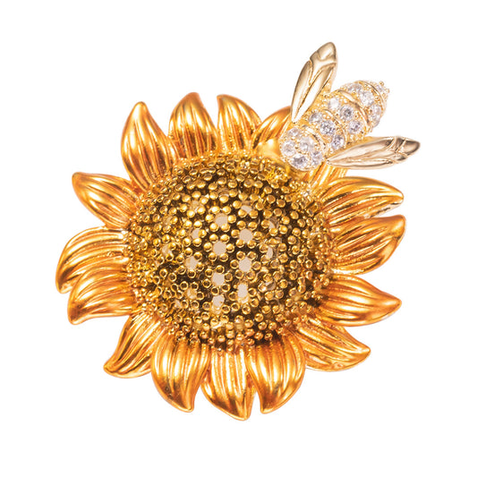 A brooch pin featuring a sunflower with a bee on top, made with cubic zirconia.