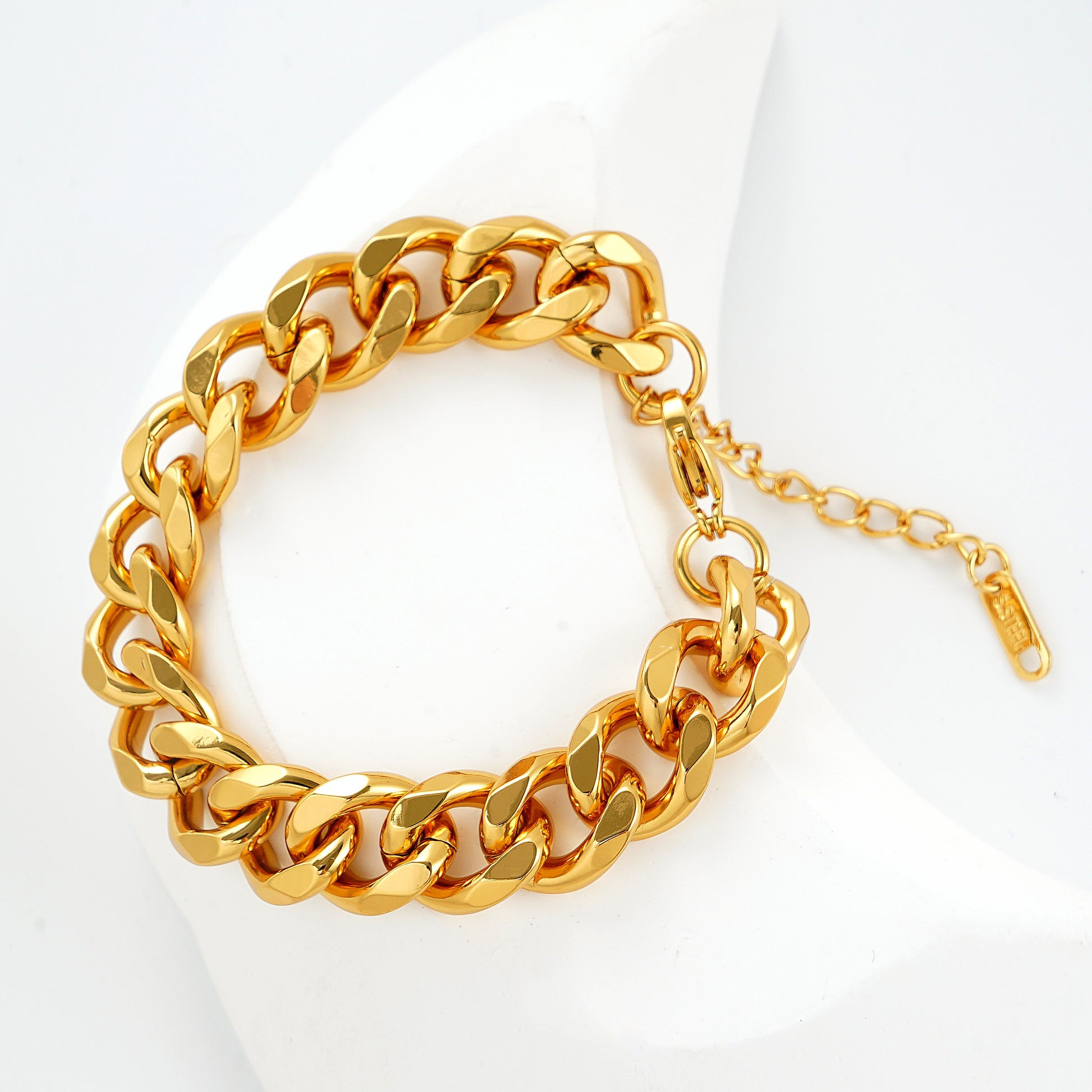 A close-up of a chunky gold Cuban link bracelet