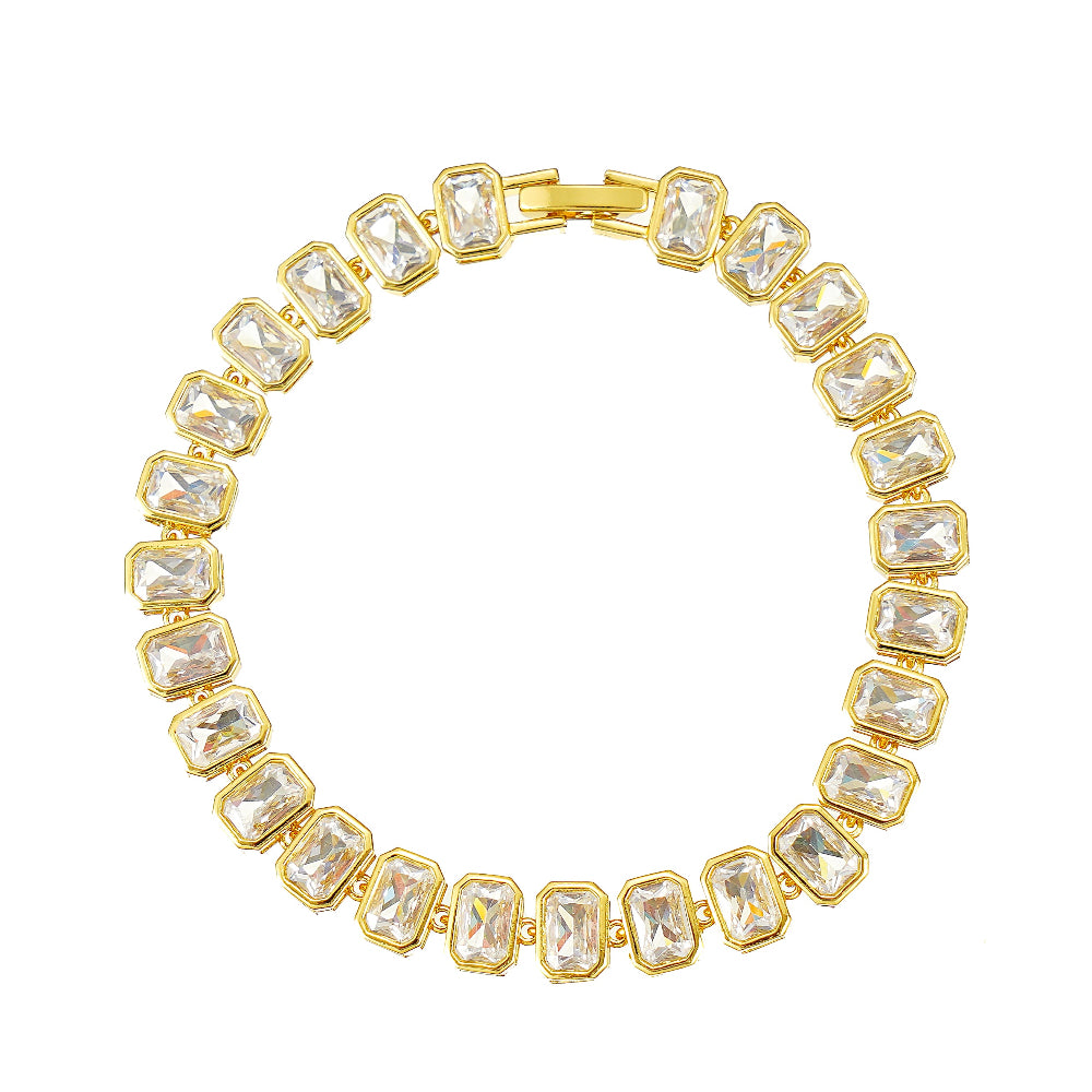 A gold-plated tennis bracelet featuring emerald-cut bezel-set clear cubic zirconia stones.
