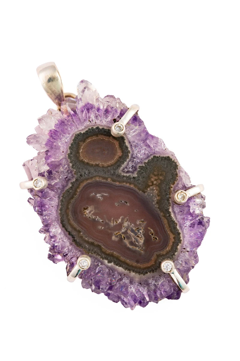 Amethyst geode pendant with embedded brown stone on a white background