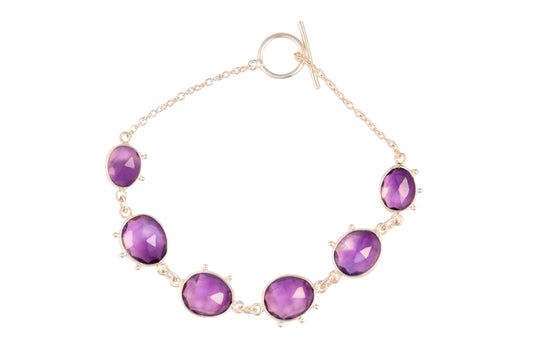 Bracelet with purple gemstones on a white background