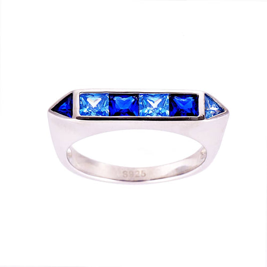 An Art Deco style sterling silver ring with multiple blue simulated sapphire stones and one aquamarine cubic zirconia.