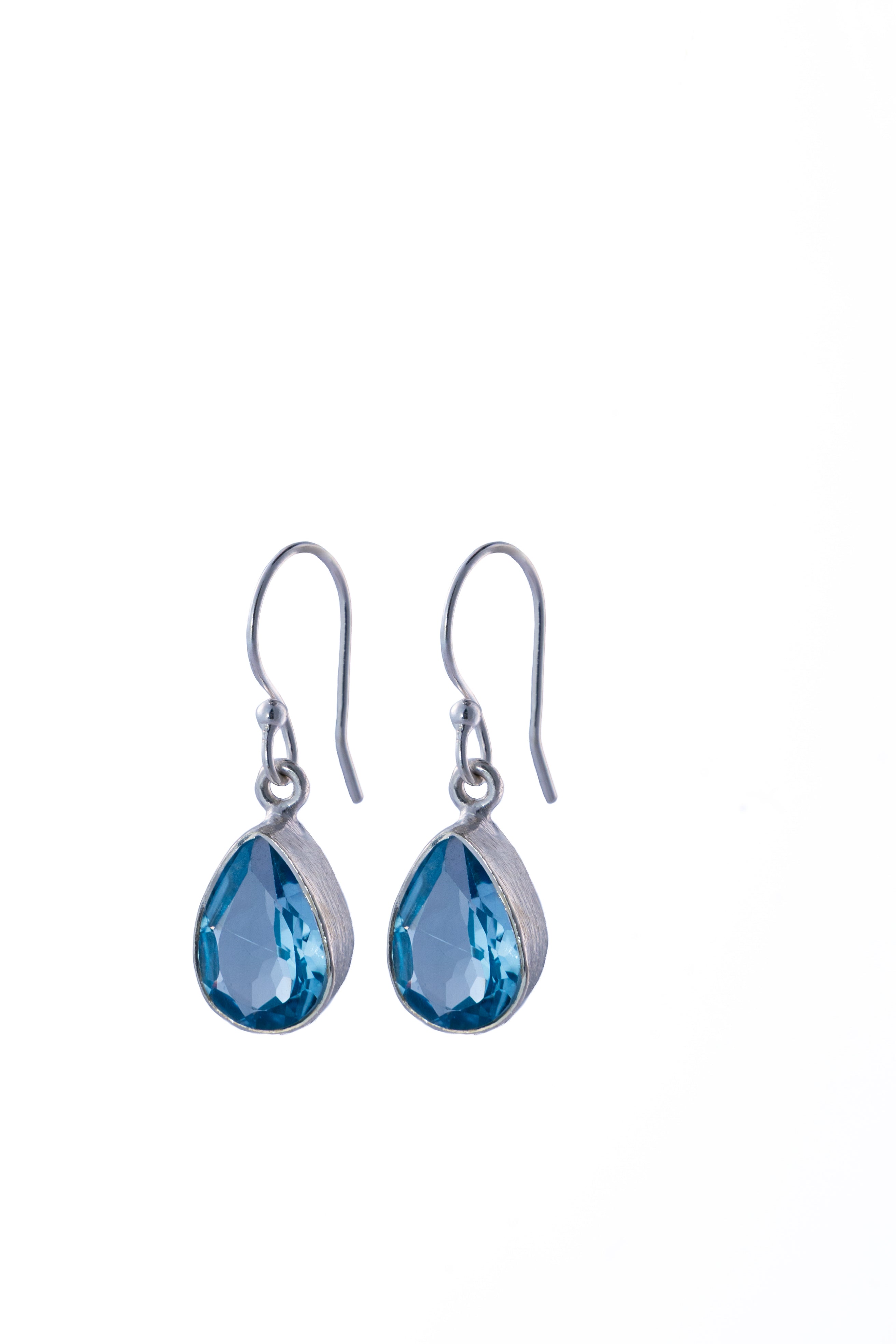 Pair of silver earrings with blue Topaz teardrop-shaped gemstones on a white background