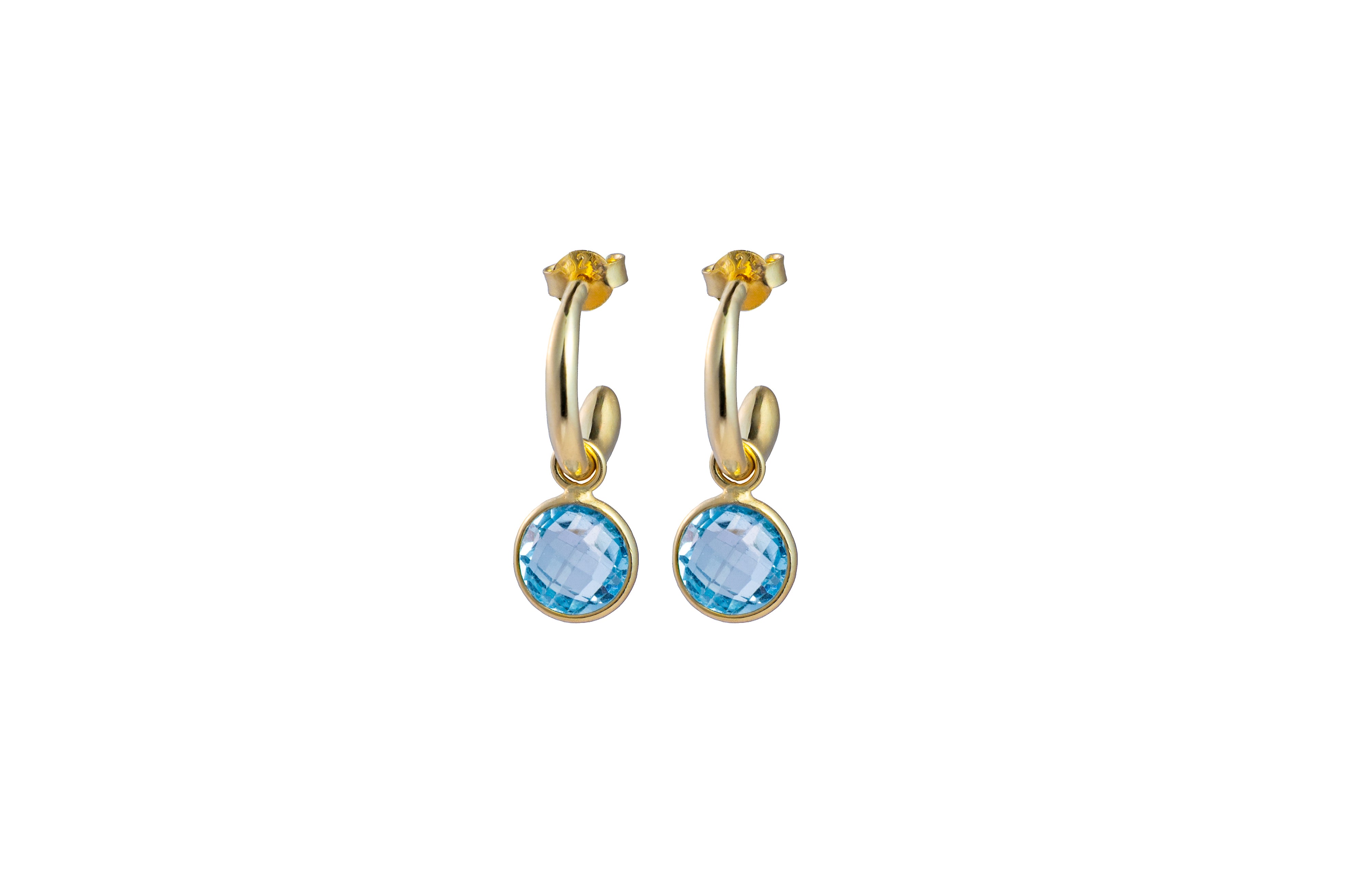 Gold hoop earrings with blue Topaz gemstones on a white background