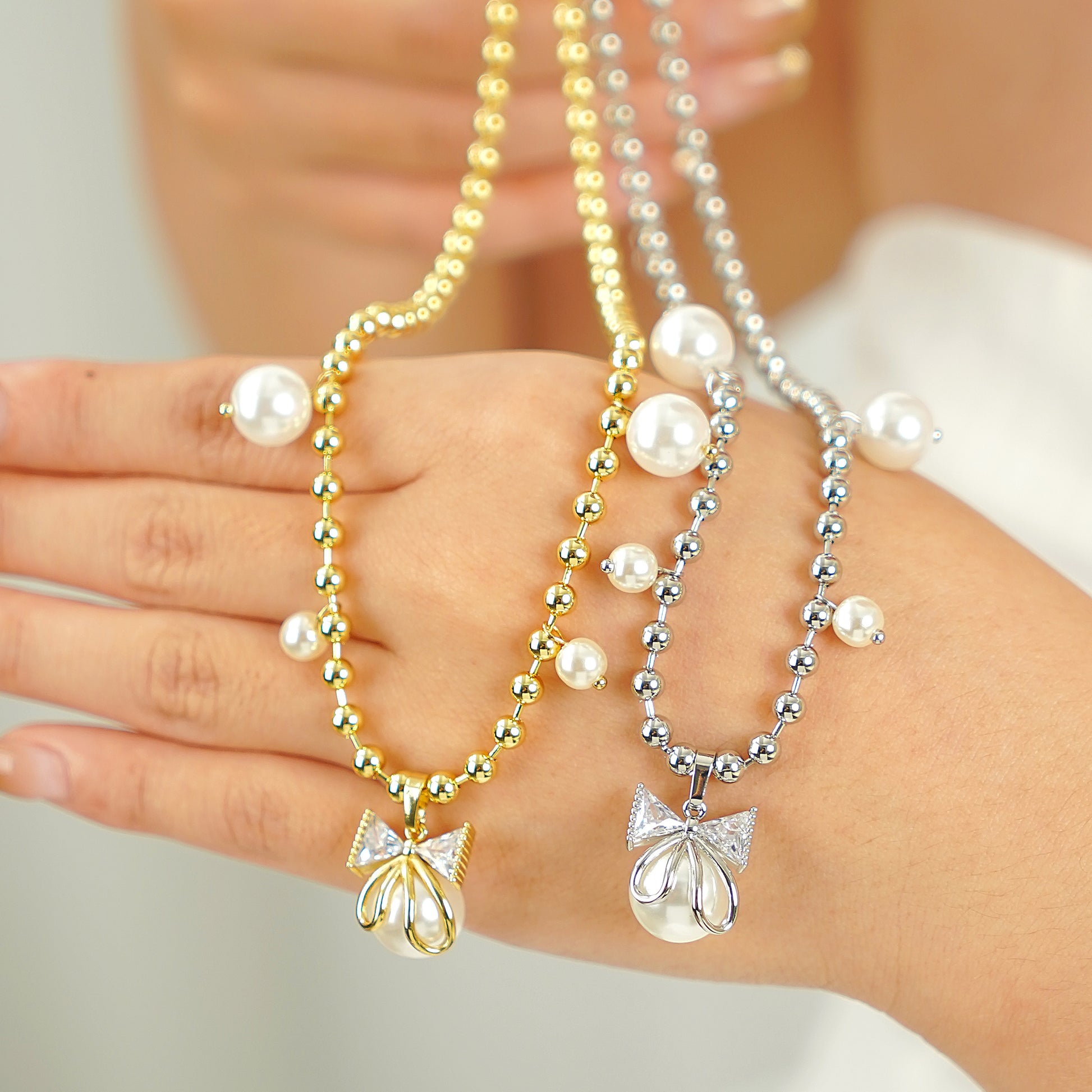 A silver bow necklace with simulated pearls and sparkling CZ stones