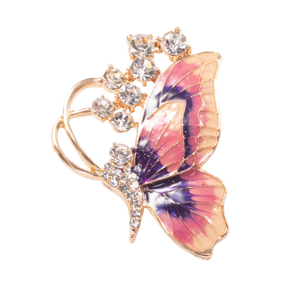 Butterfly-shaped brooch with pink and purple wings and crystal accents on a white background