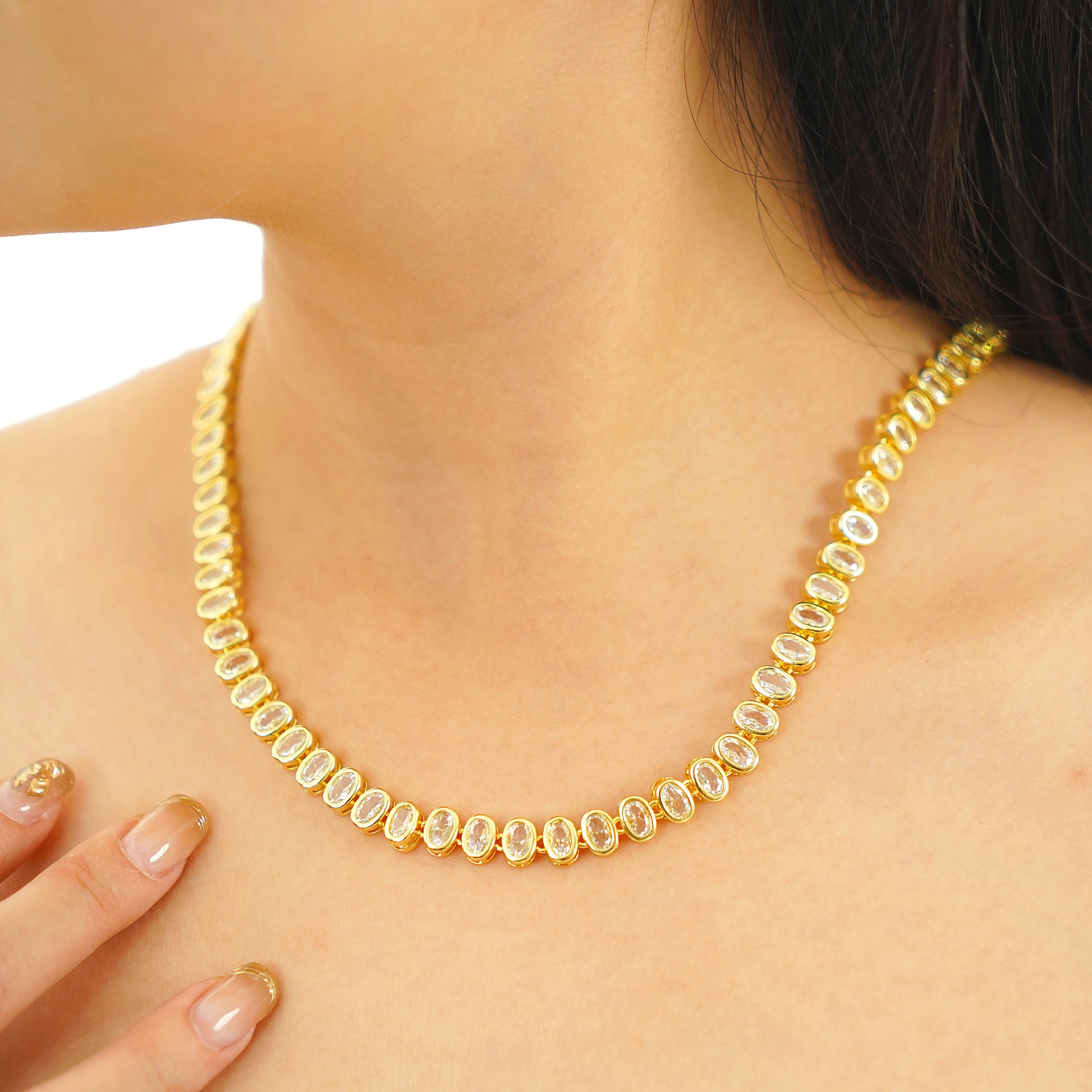 Close-up of a woman wearing an oval CZ tennis necklace