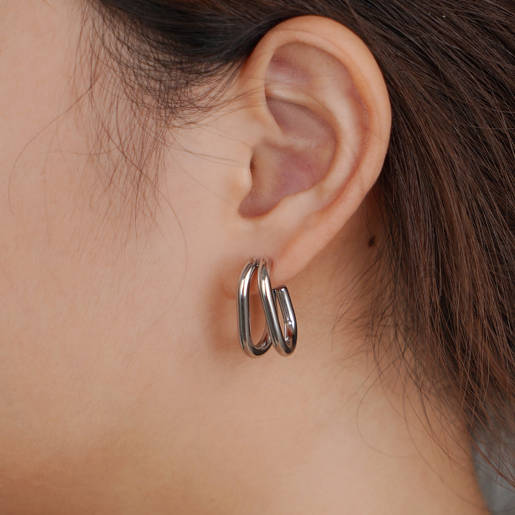 Close-up of an ear wearing a silver hoop earring 