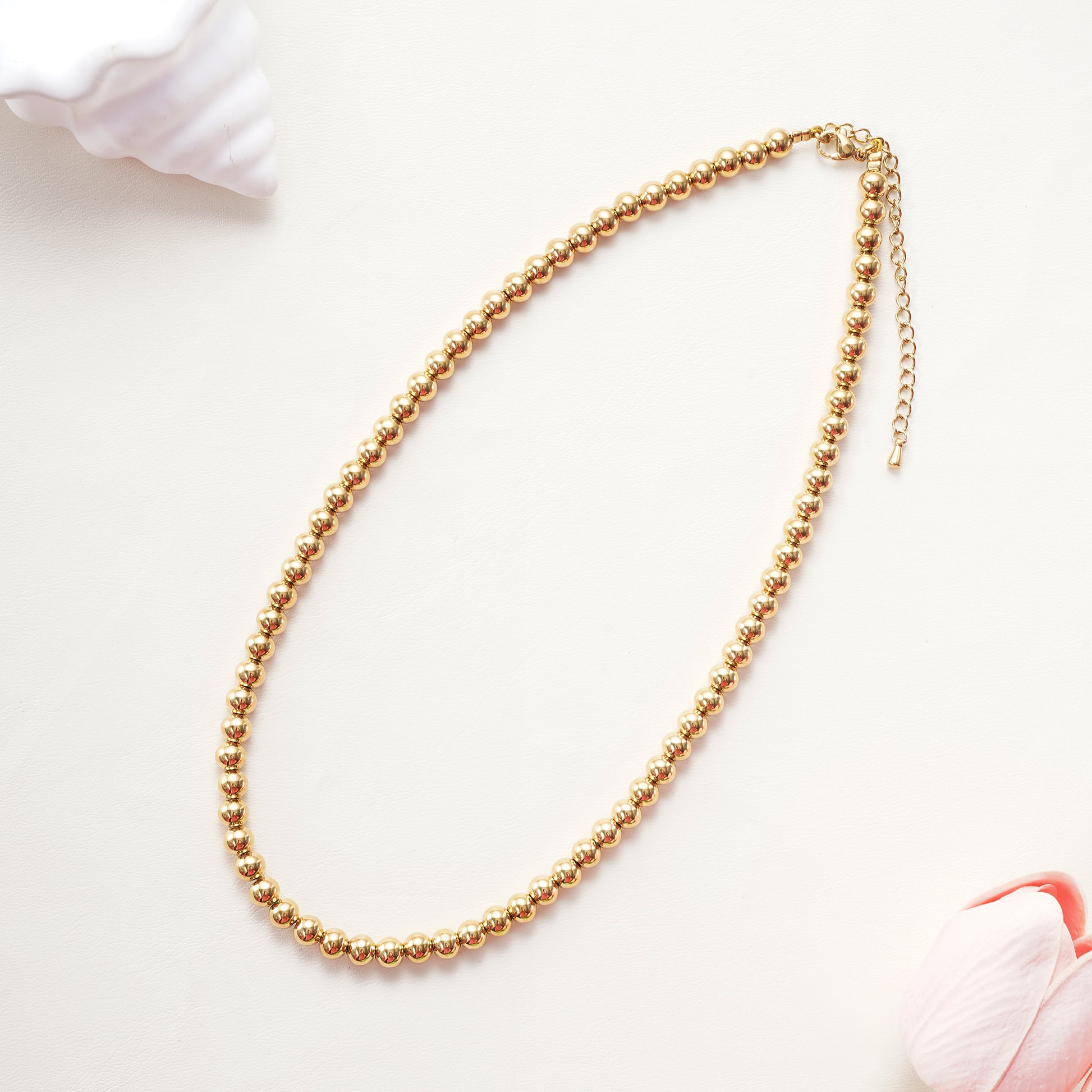 Close-up of the 6mm gold beads and the 2-inch extender chain with a secure lobster clasp
