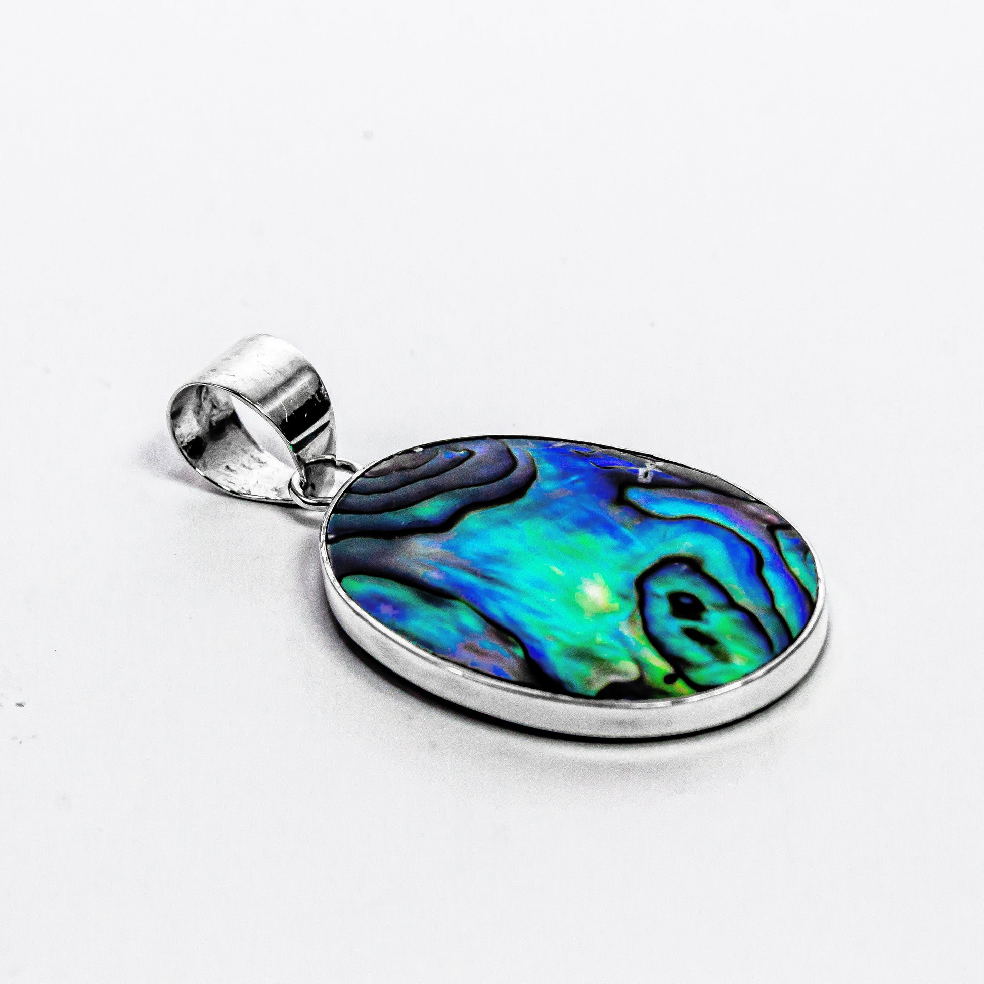 Close-up of the natural blue and green patterns in the abalone shell and the fine detail of the Bali silver craftsmanship