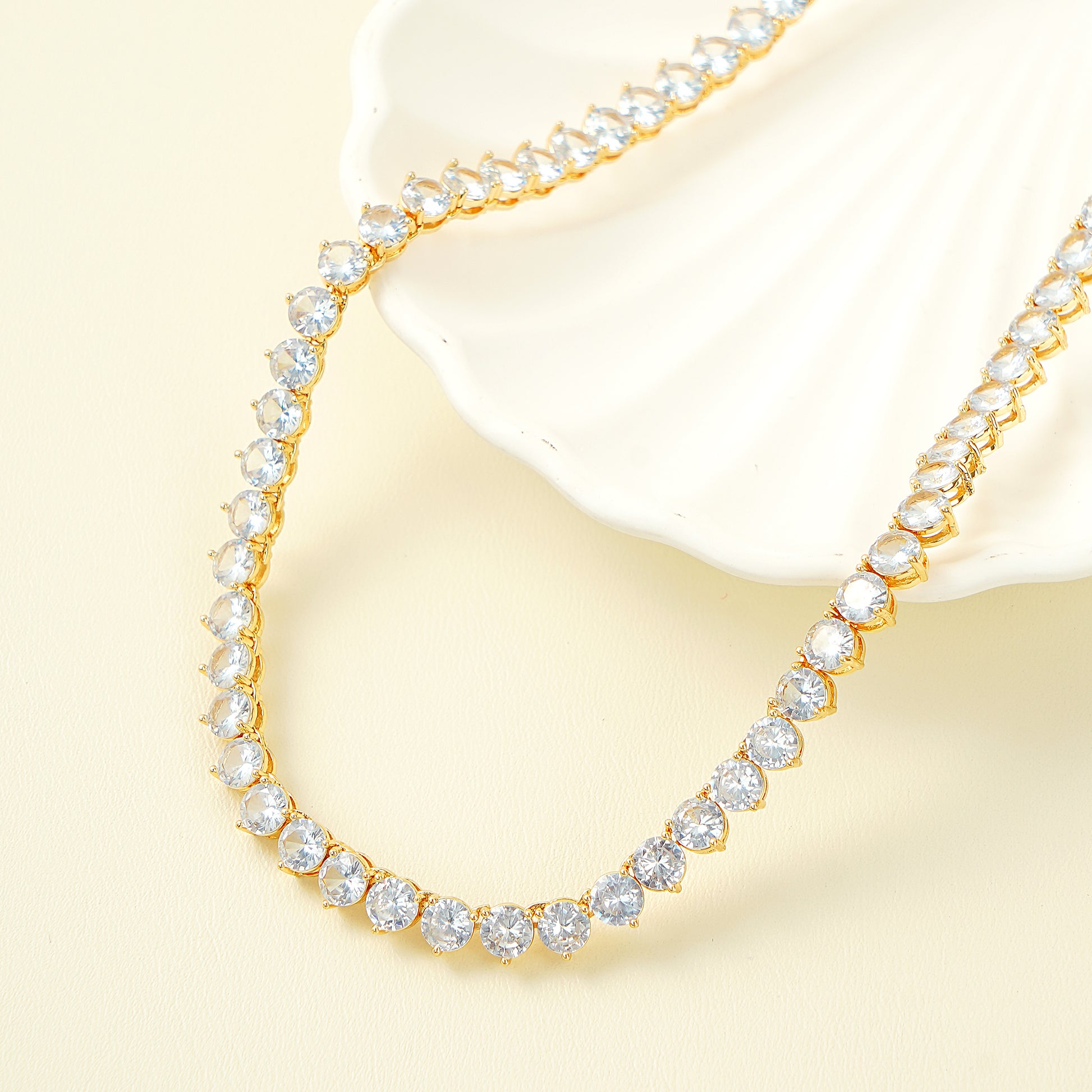 Close-up of the prong-set cubic zirconia stones and the adjustable extender clasp on the gold tennis necklace