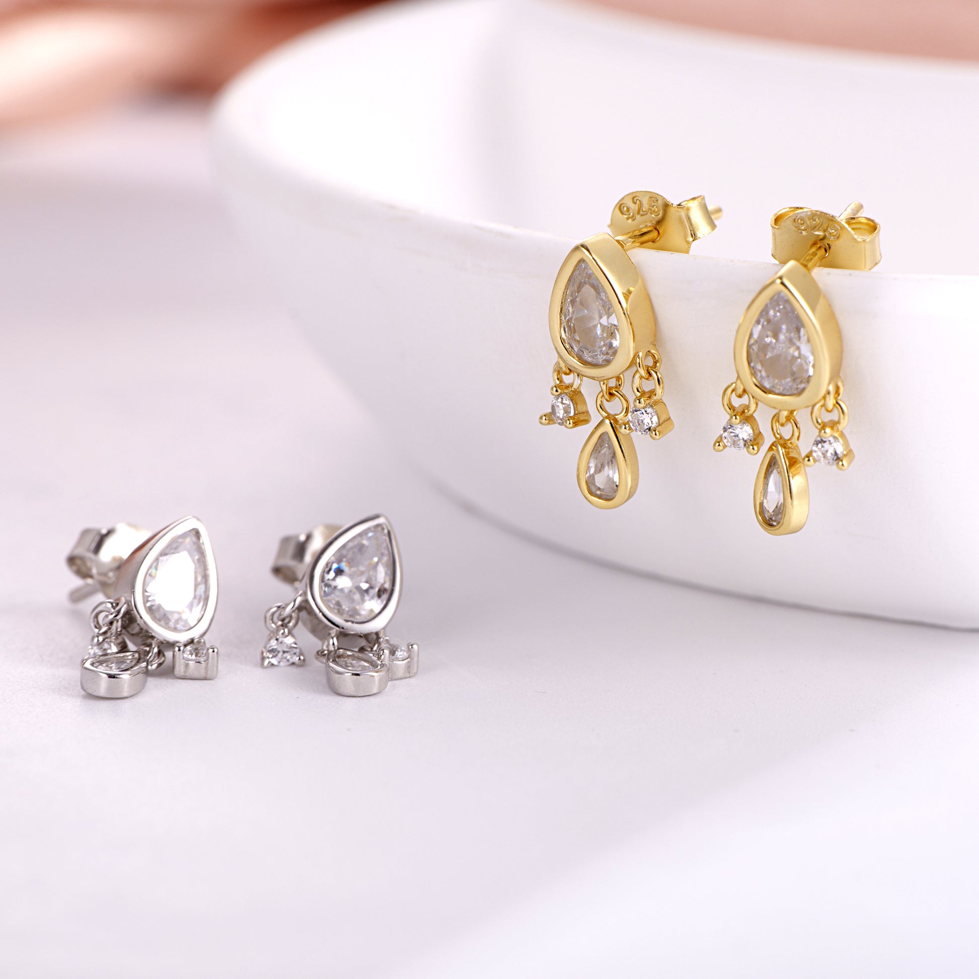 Close-up of the teardrop-shaped simulated diamond facets on silver dainty dangle earrings
