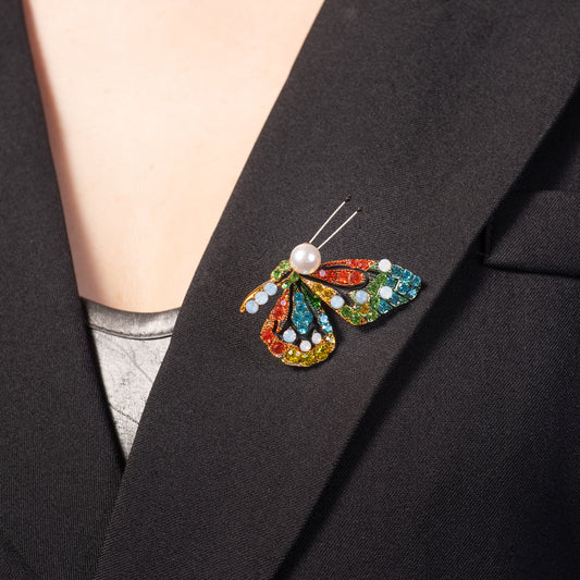 Colorful butterfly brooch with pearl center on a black blazer