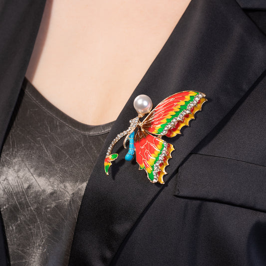 Colorful butterfly brooch with pearl center on a black blazer