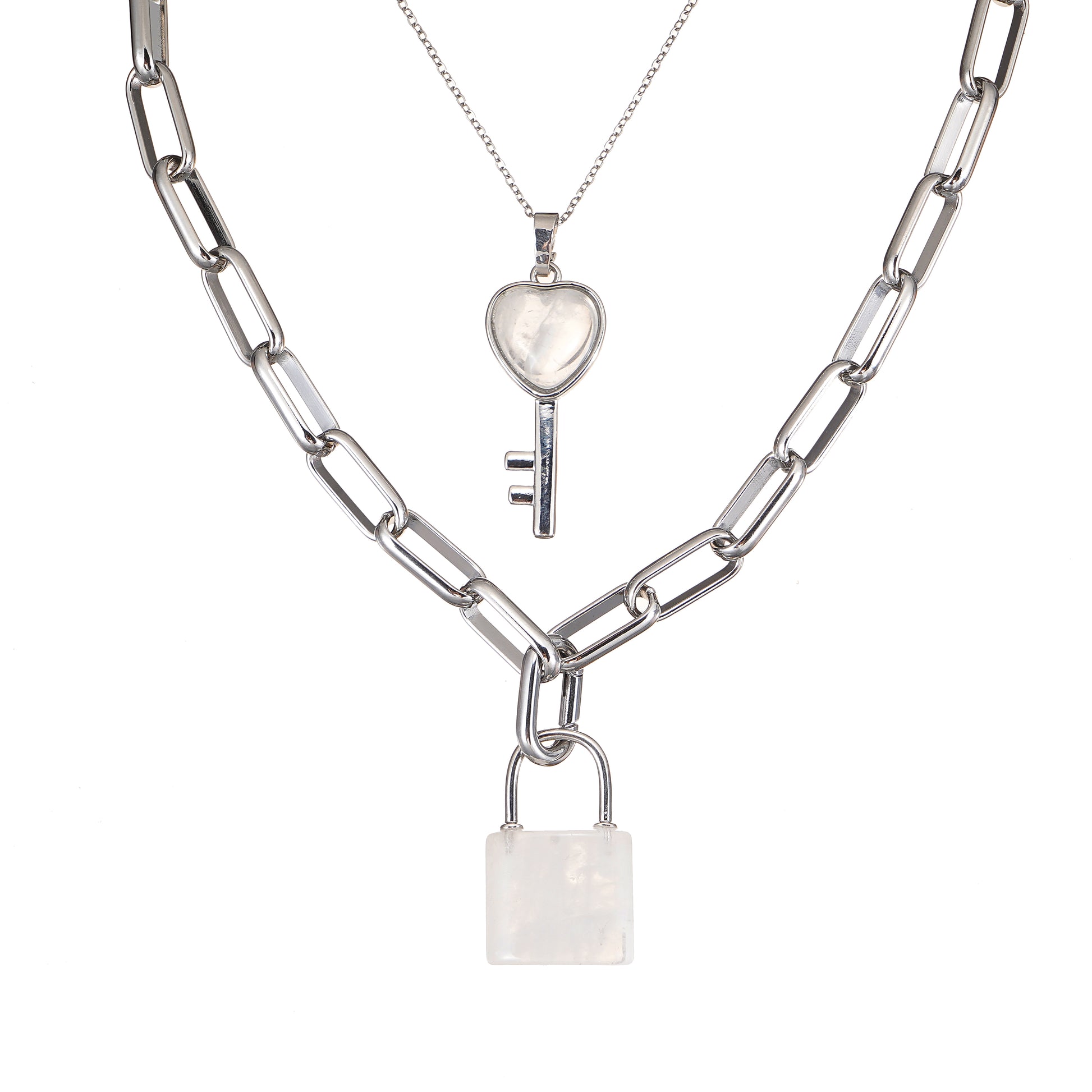 Two silver necklaces with Crystal Quartz heart and lock pendants on a white background