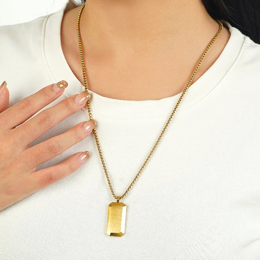 Gold necklace with a rectangular Dog Tag pendant worn by a person on a white background