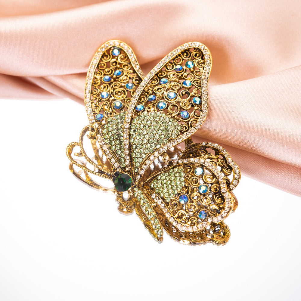 Decorative butterfly brooch with gemstones on a white background