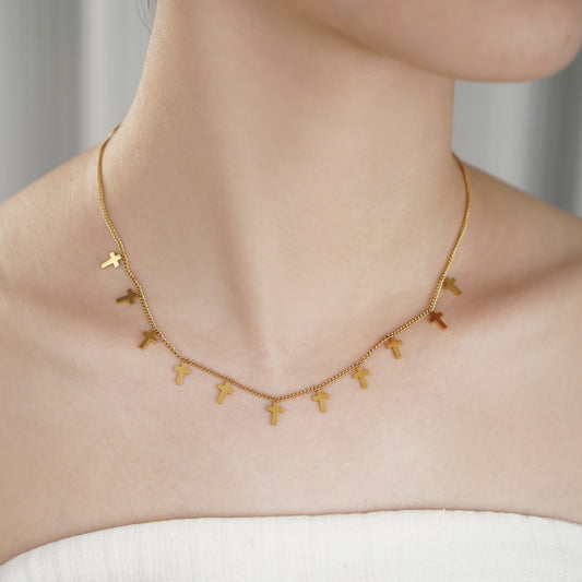 Minimalist 18k gold IP stainless steel cross charm necklace on a thin cable chain.