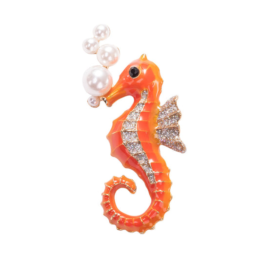 Detailed colorful enameled seahorse brooch pin with a gold-tone outline on a white background