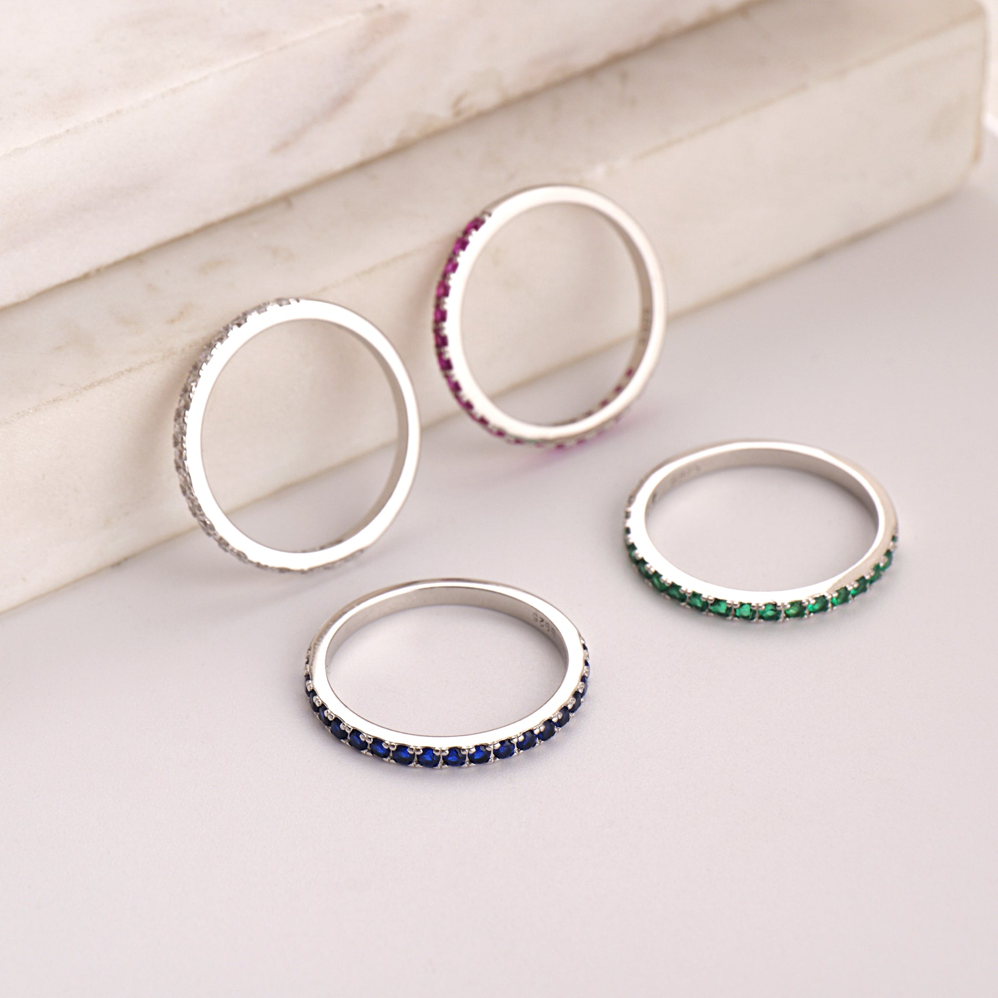 Four silver rings with colored gemstones 