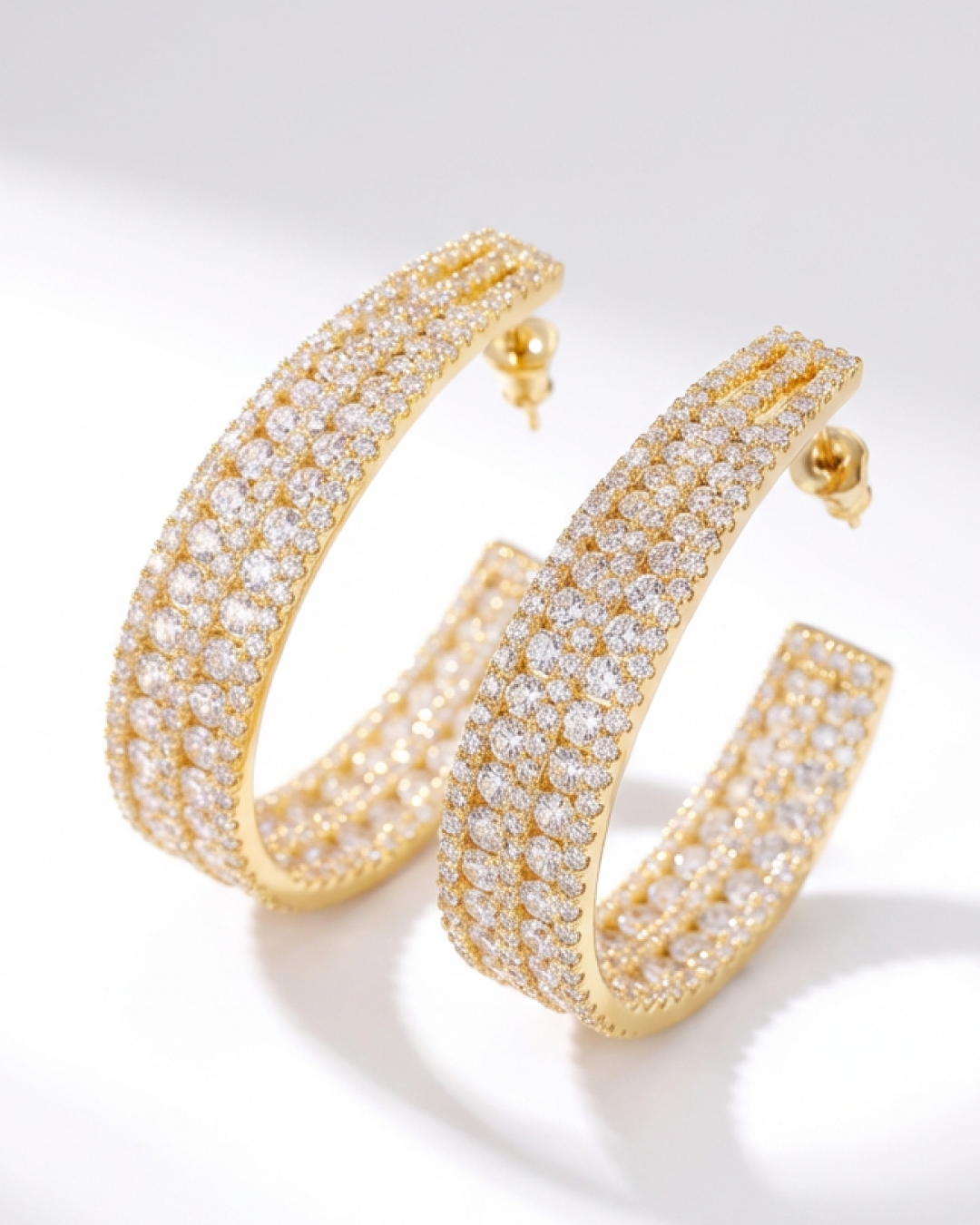 Gold hoop earrings with diamond accents on a white background