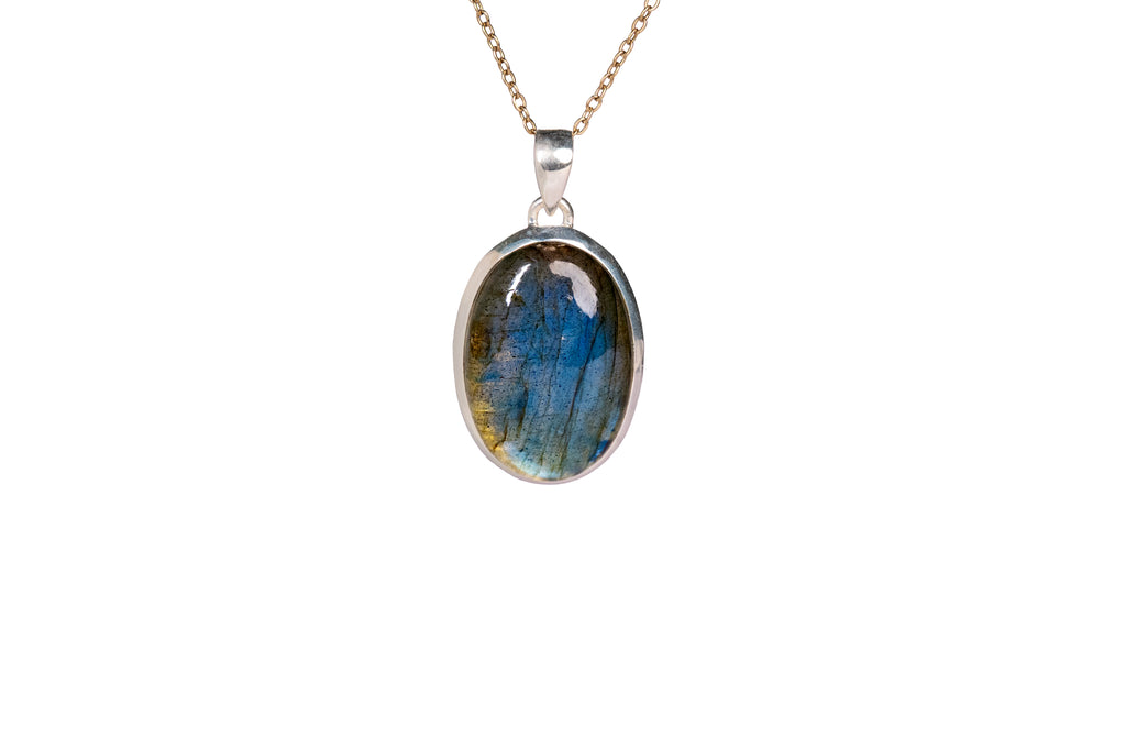 A Labradorite pendant in golden chain against a white background