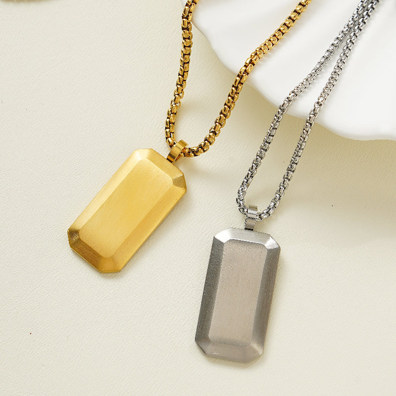 Two rectangular Dog tag pendants on gold and silver chains on a light background