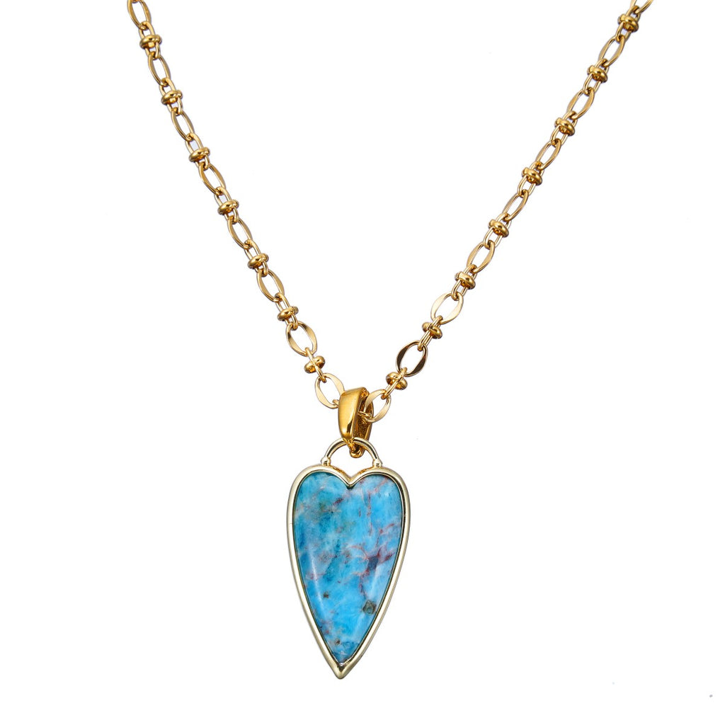 Necklace with a heart-shaped blue pendant on a gold chain against a white background