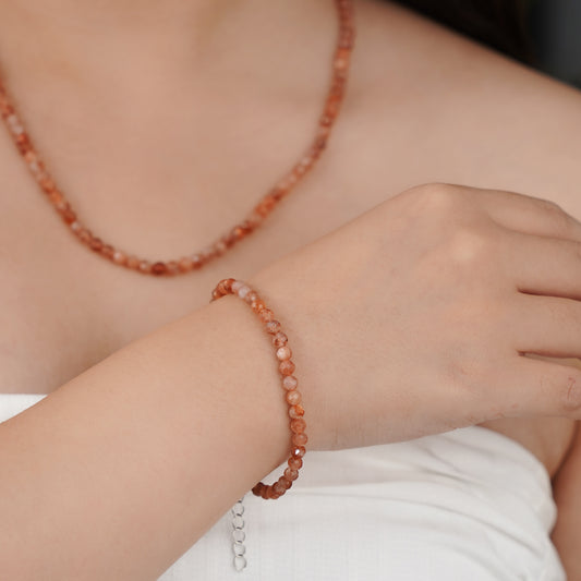 Person wearing a red beaded bracelet 