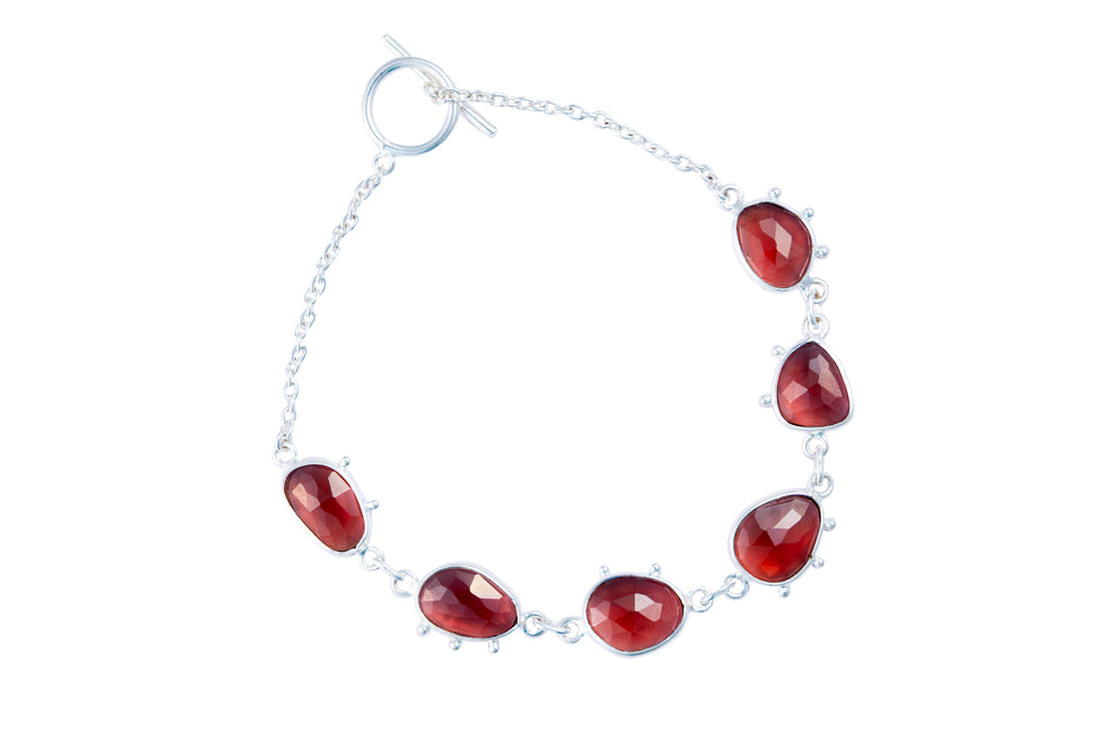 Bracelet with red teardrop-shaped gemstones on a white background