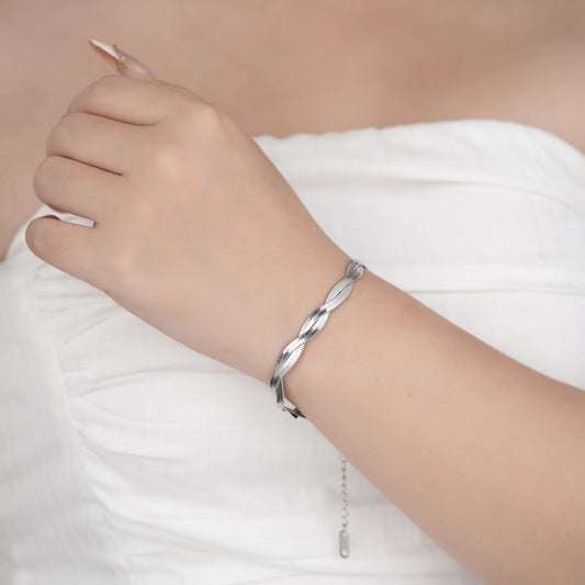 Silver bracelet on a person's wrist with a blurred background