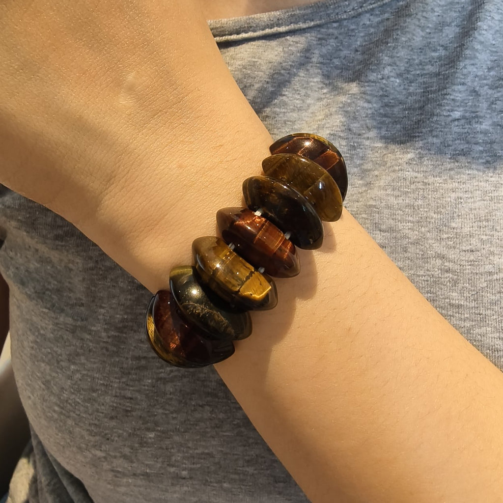 Stacked tiger's eye bracelets on a wrist 