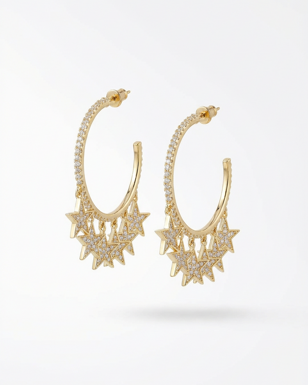 Gold hoop earrings with star-like designs on a white background