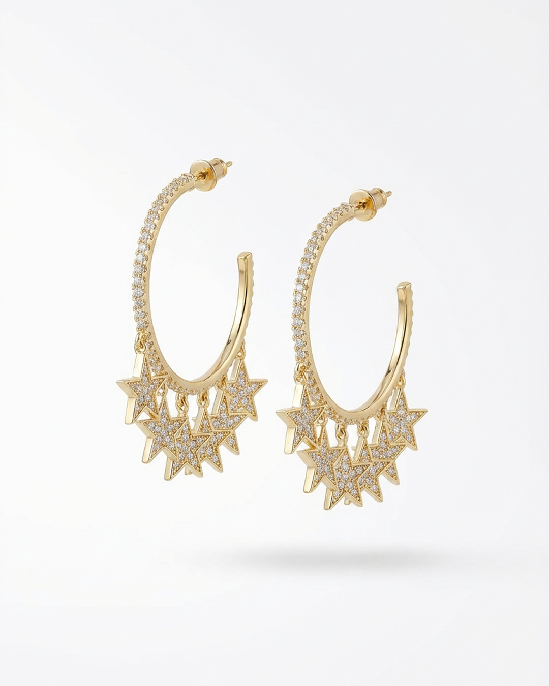 Gold hoop earrings with star-like designs on a white background