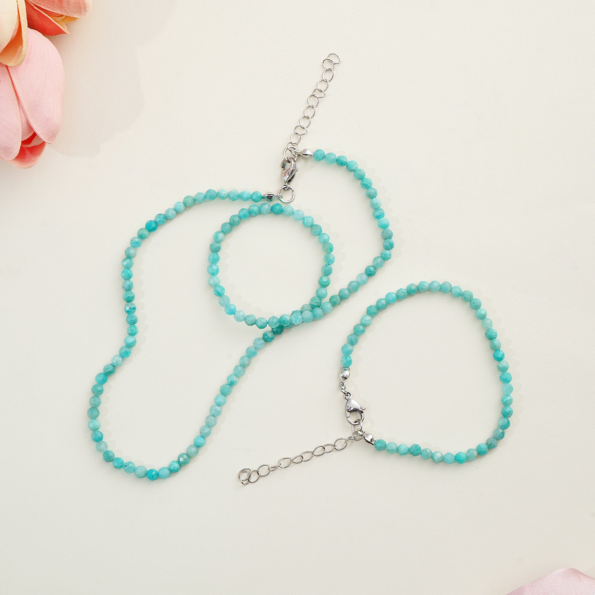 Turquoise beaded necklace on a light background with flowers