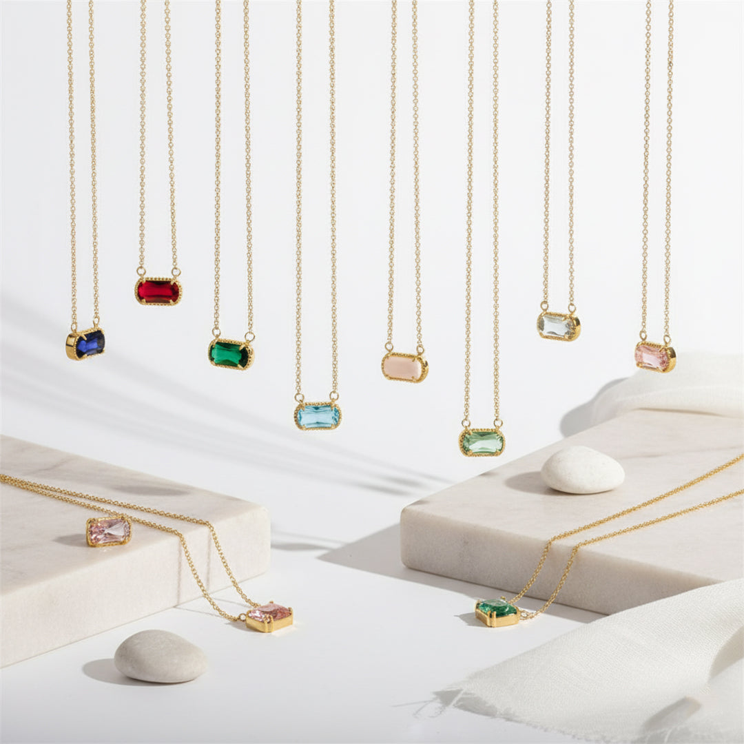 Gold necklaces with colorful gemstones on a white background