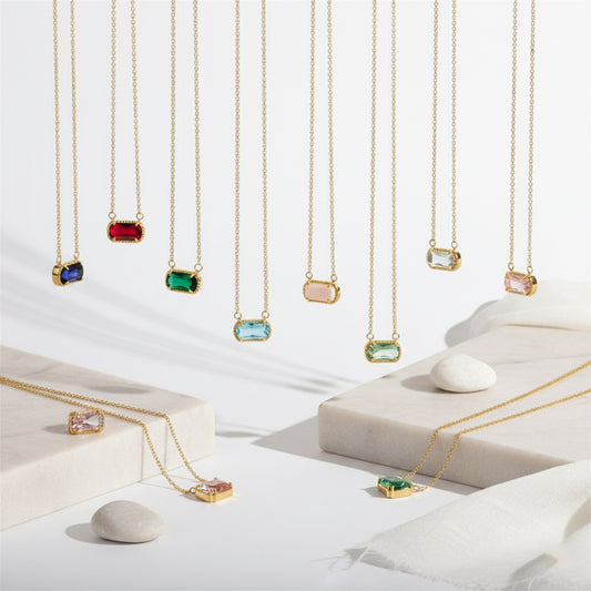 Gold necklaces with colorful gemstones on a white background