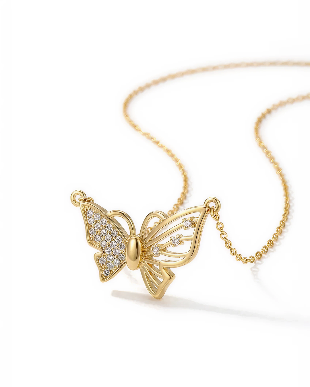 Gold butterfly necklace on a white background