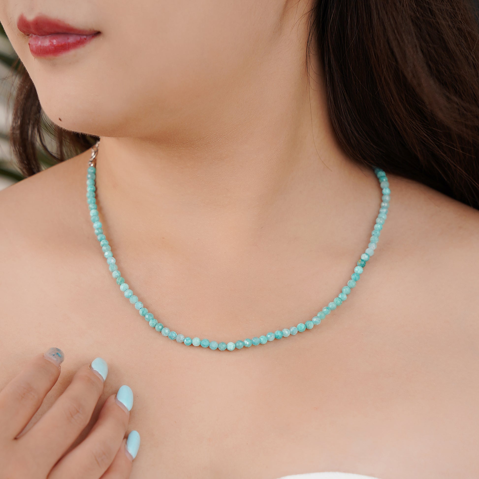 Turquoise beaded necklace worn by a person
