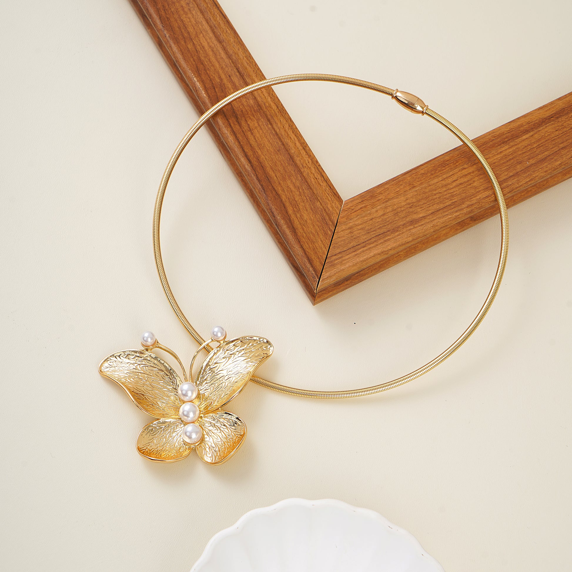 gold butterfly motif and lustrous white pearls on a collar necklace