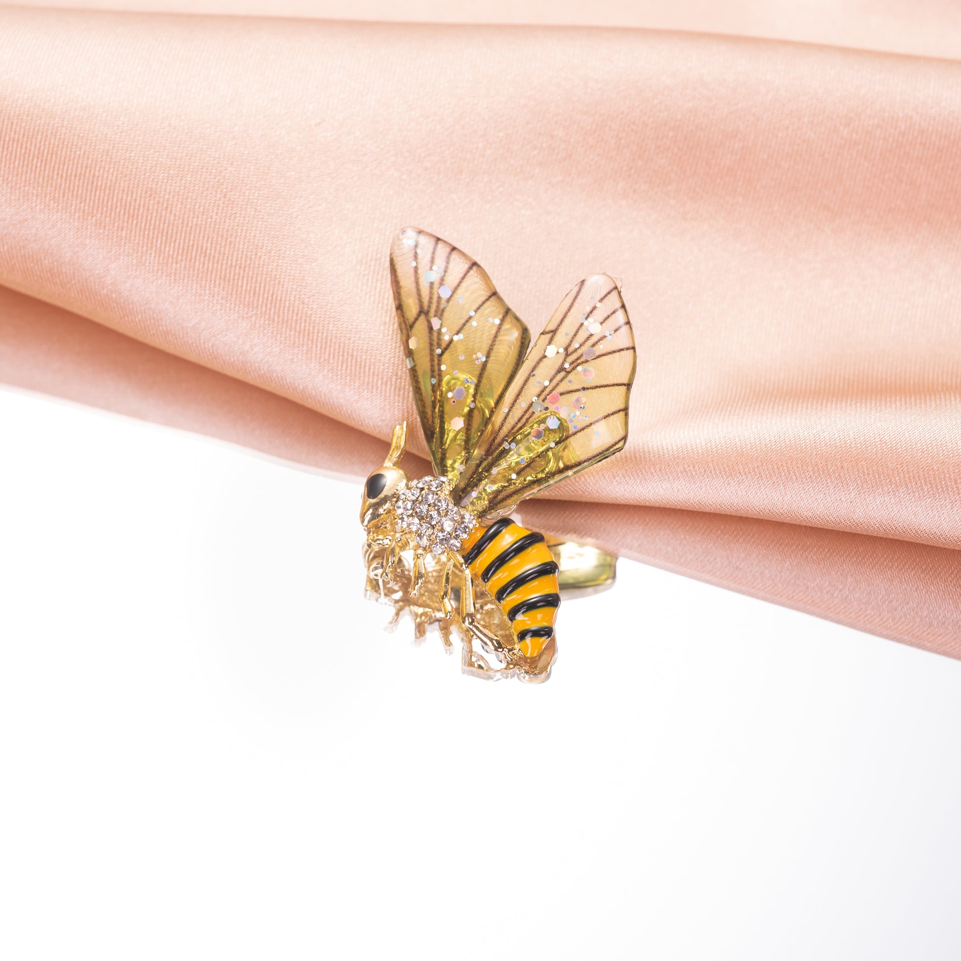 A vibrant green and yellow bee-shaped enamel brooch pin with sparkling accents.