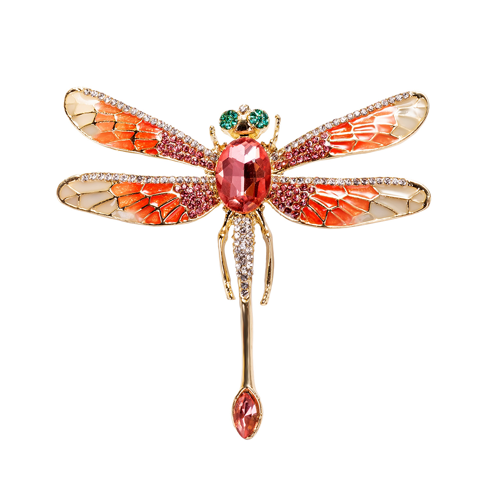 Decorative dragonfly brooch with gemstones on a white background